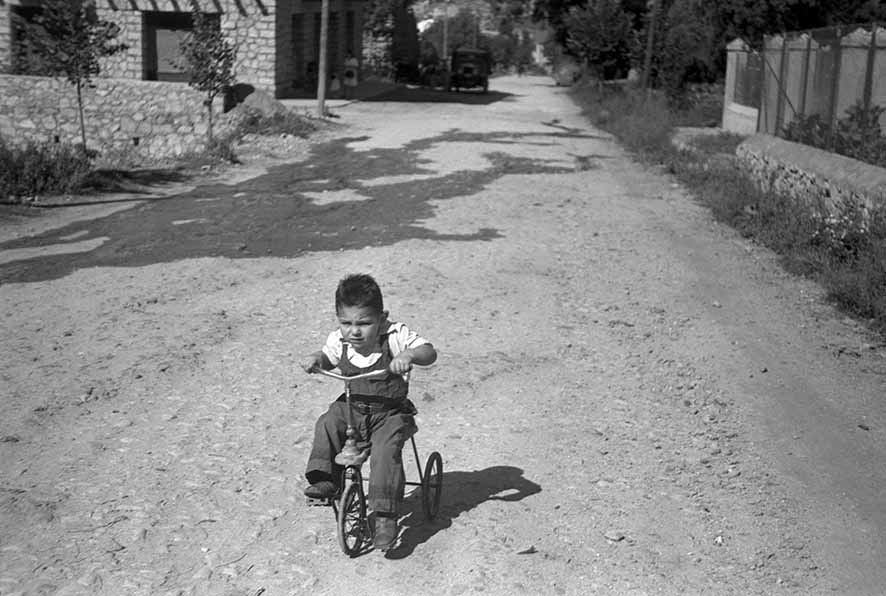 40_FAM_6308_25: Instantània d’un nen amb un tricicle a l’avinguda Carlemany