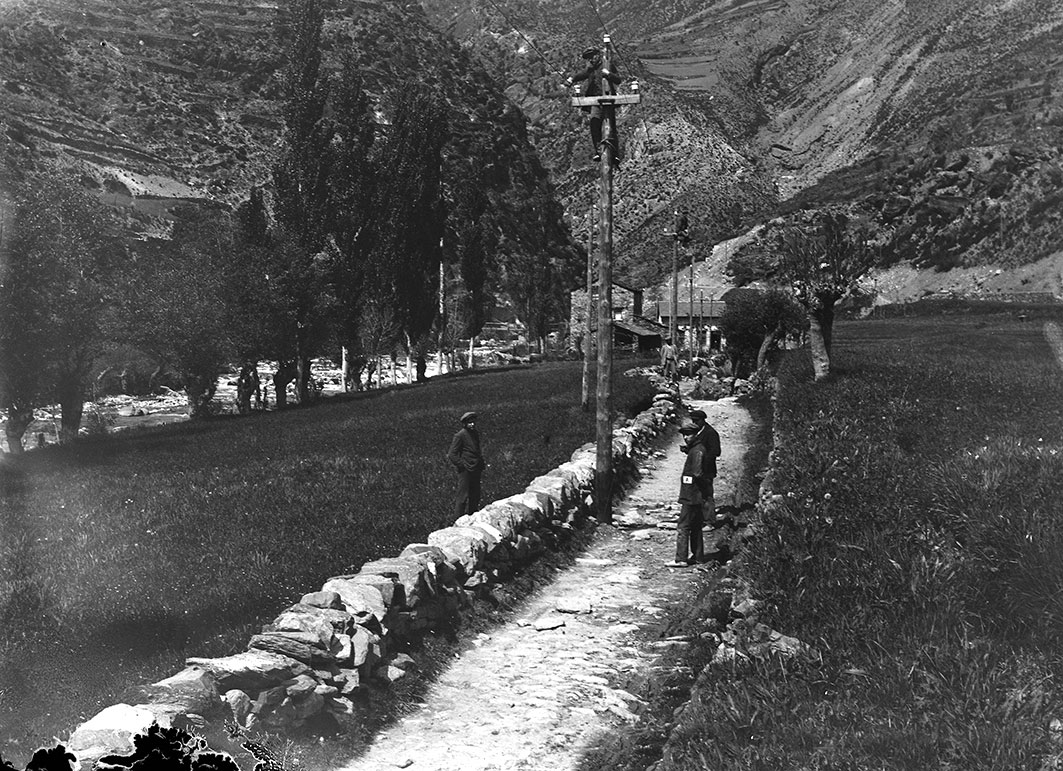 CRA_0082: Instantània de sis homes treballant en la instal·lació dels pals de línia elèctrica