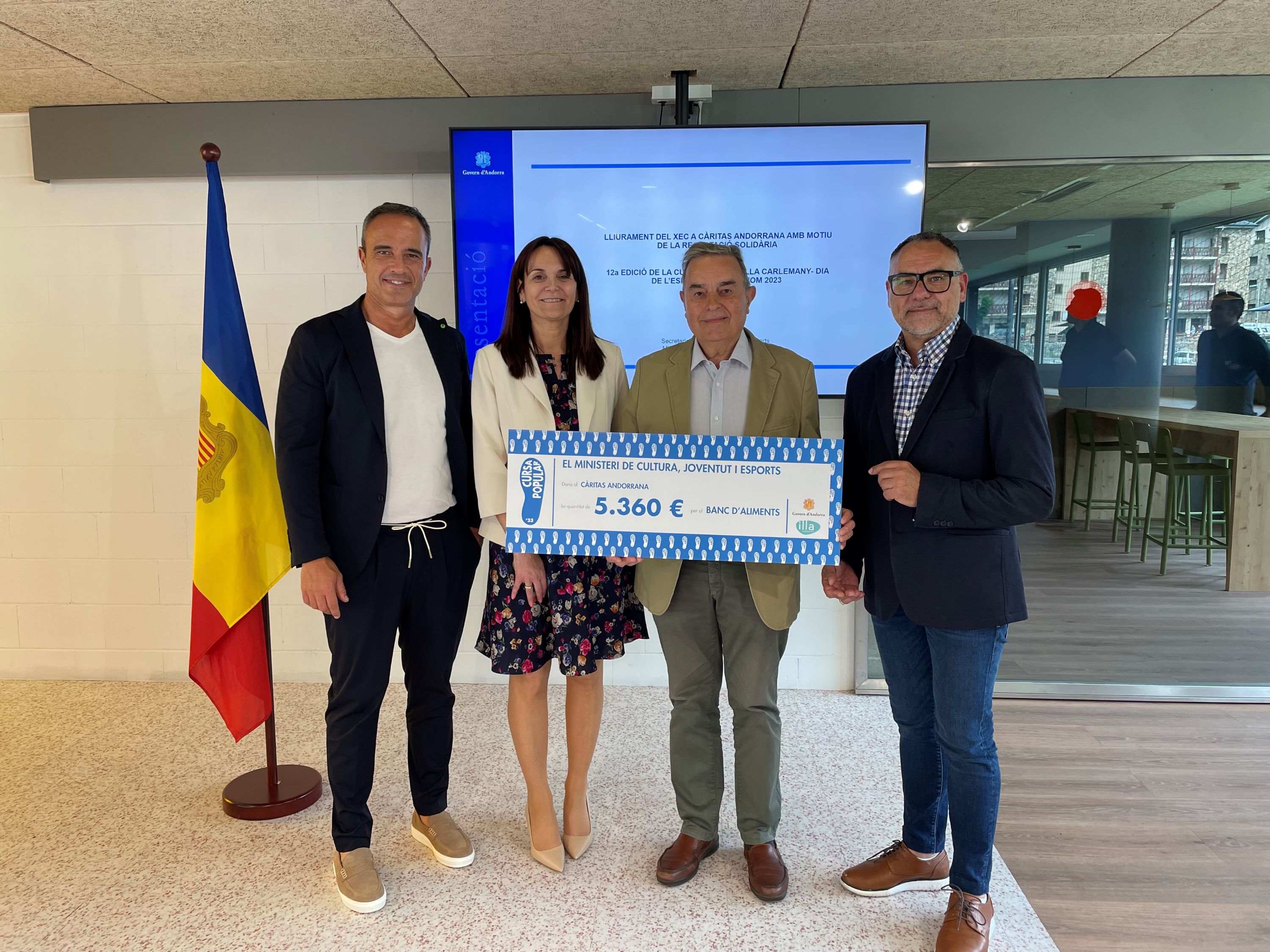 El Govern entrega a Càritas un xec de 5.360 euros, recaptats en la  venda de les samarretes de la Cursa Popular Illa Carlemany