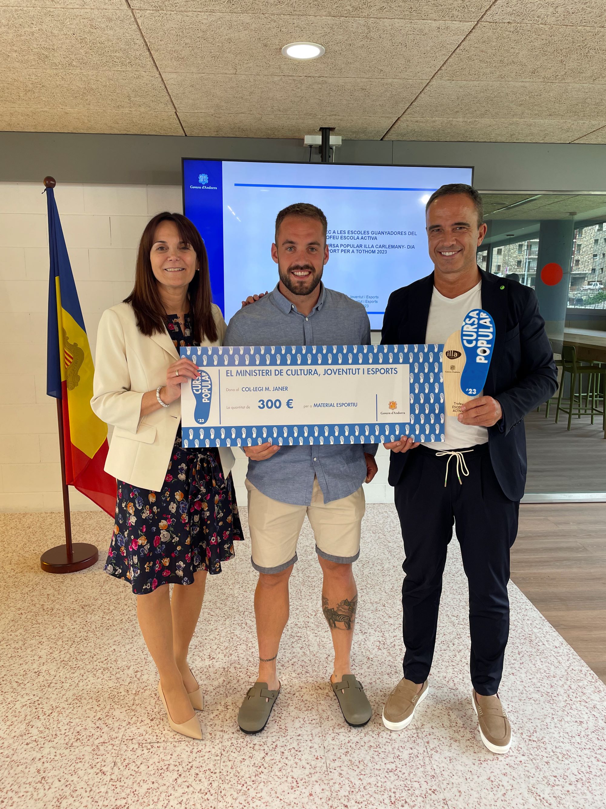 El Govern entrega a Càritas un xec de 5.360 euros, recaptats en la venda de les samarretes de la Cursa Popular Illa Carlemany